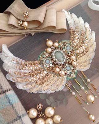 Bordado artístico de corazón con alas en lentejuelas, perlas y cristales, técnica de alta costura.