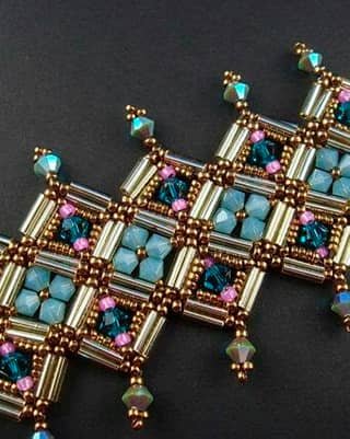 Joyería bordada con canutillos dorados y mostacilla azul, diseño geométrico de alta precisión.