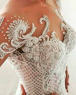 Escote de vestido de novia con bordado de encaje, hilo y perlas sobre tul transparente.