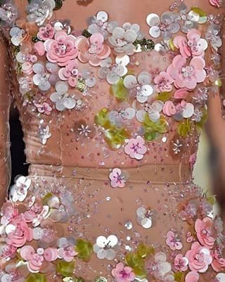 Vestido bordado con flores de lentejuelas rosadas y blancas sobre tela nude.